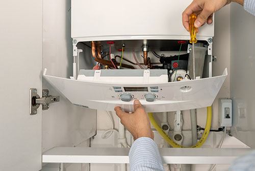 HVAC technician repairing an indoor boiler in Sun City