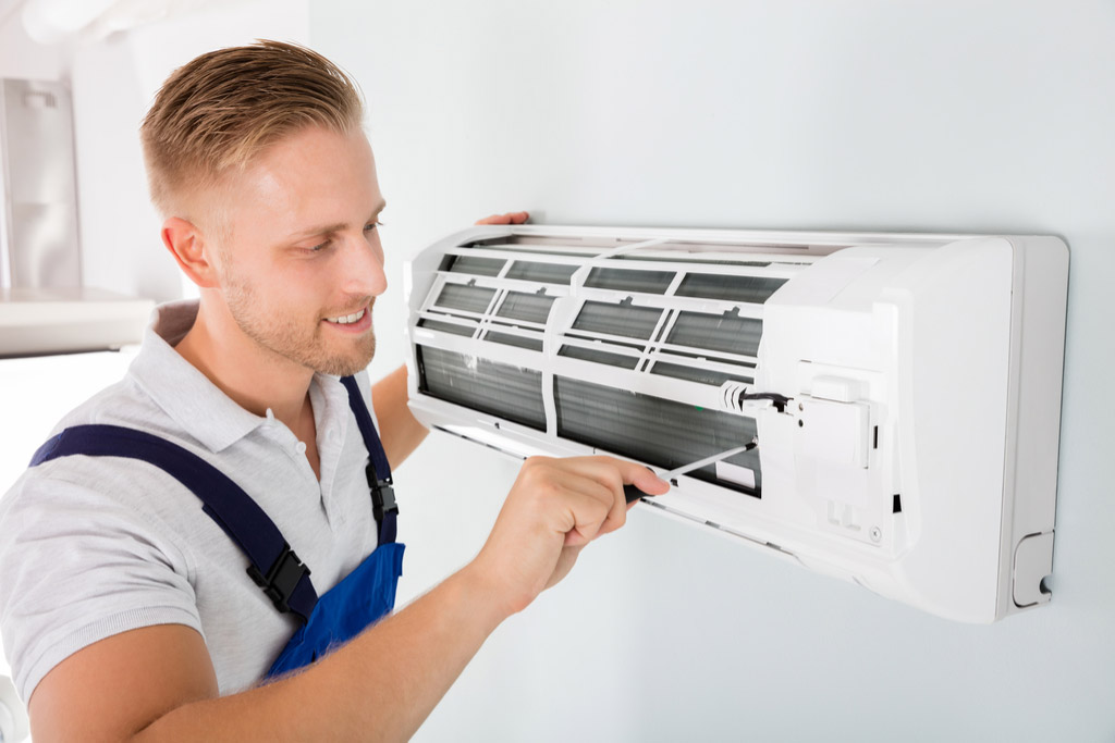 HVAC technician performing ductless air conditioning maintenance in Sun City
