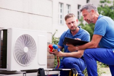 ac-installation-in-claremont-ca HVAC technicians reviewing an outdoor air conditioning unit in Sun City, AZ
