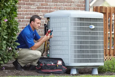 design-air-heating-and-air-conditioning-decatur-il-05 – Copy HVAC technician inspecting an outdoor air conditioning unit in Sun City, AZ