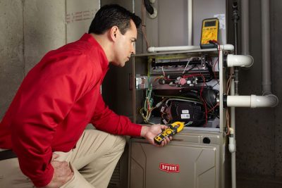 furnace repair Heating and air conditioning technician servicing an indoor furnace in Sun City, AZ
